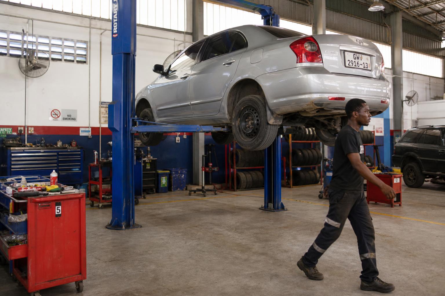 Modern car on a hydraulic lift in K. Osei Motors workshop